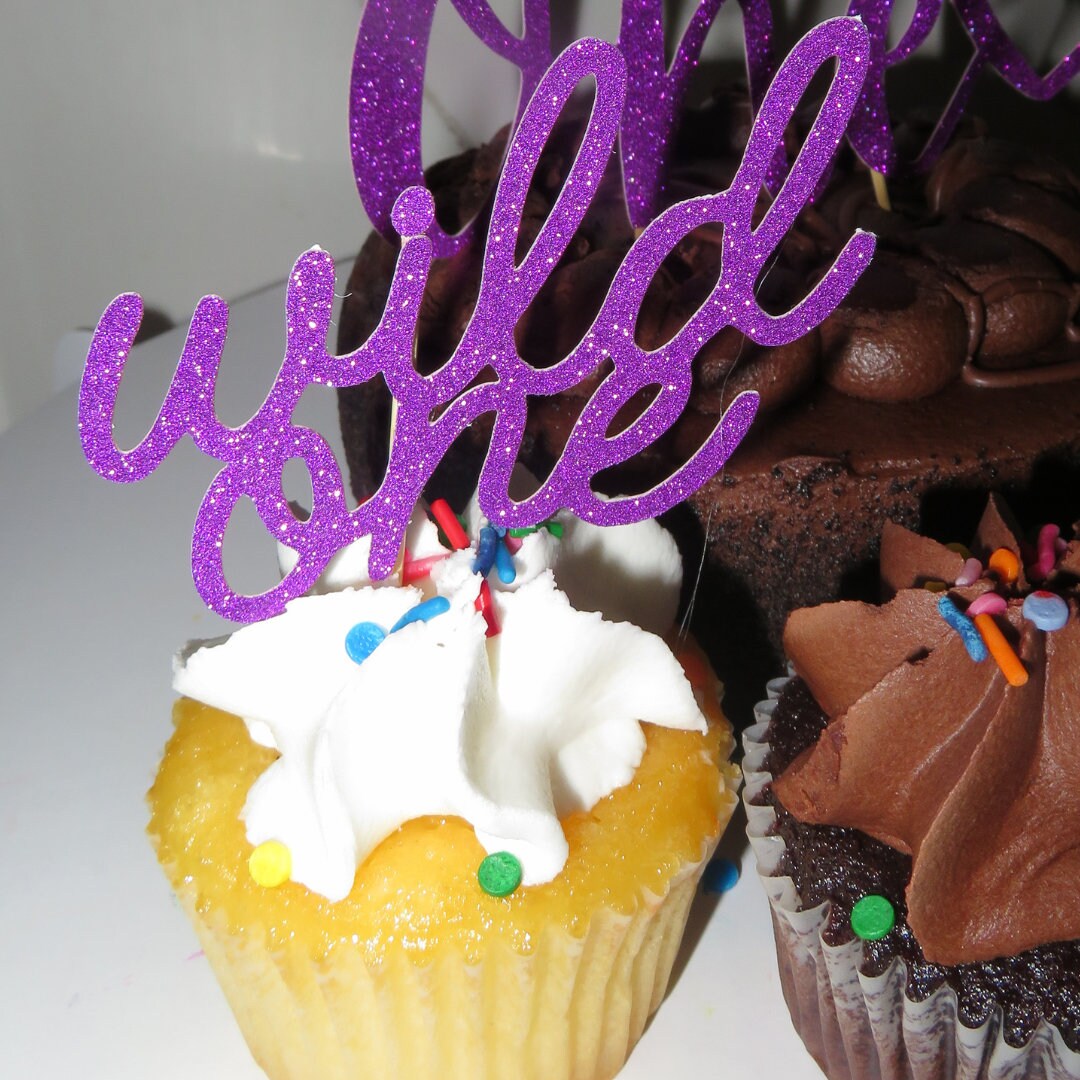 Purple glitter Wild One cupcake topper displayed on a cupcake